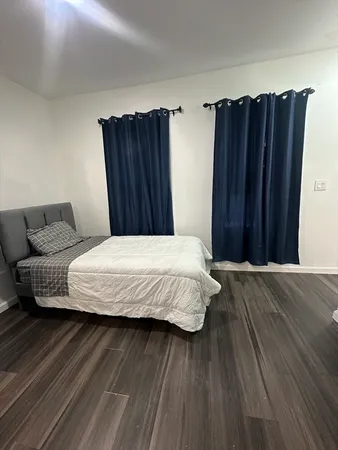 a bedroom with a bed and wooden floor