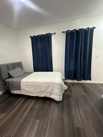 a bedroom with a bed and wooden floor