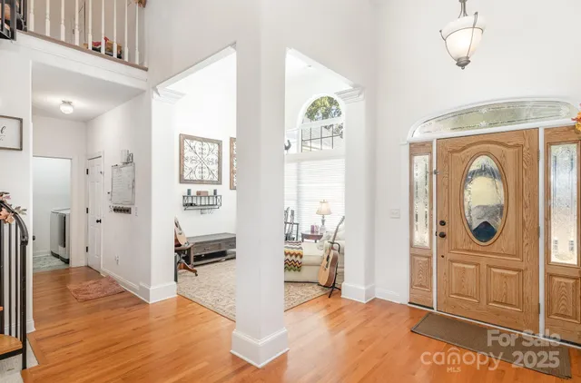 a view of a hallway with bathroom and wooden floor