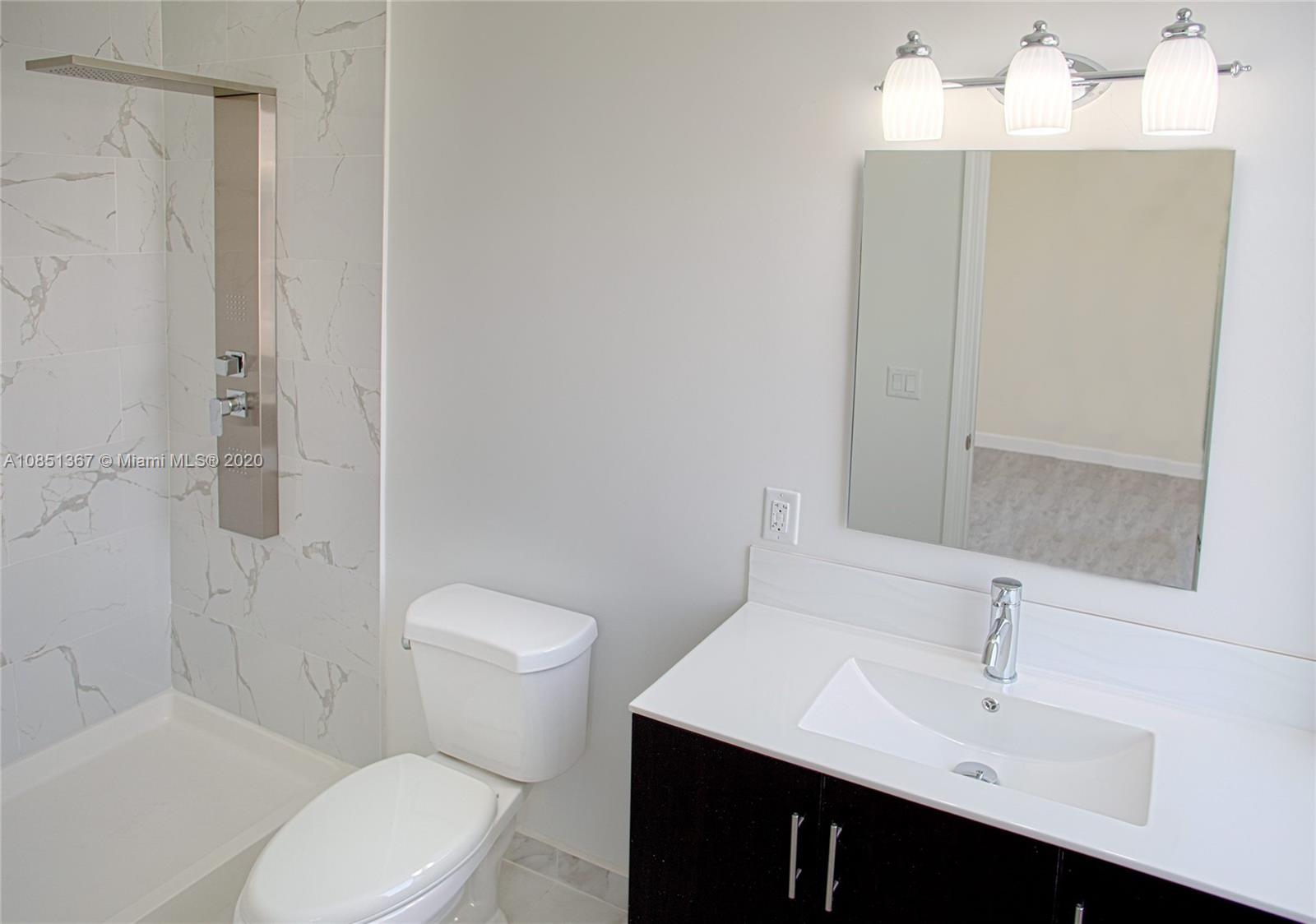 13724 Southwest 259th Street Homestead, FL 33032 - Photo 14 of 20 a bathroom with a sink vanity mirror and toilet
