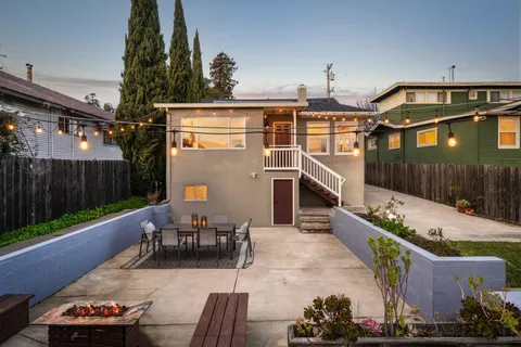 a view of a patio with couches table and chairs with wooden fence