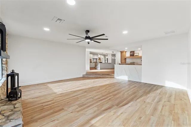 a view of empty room with wooden floor and window