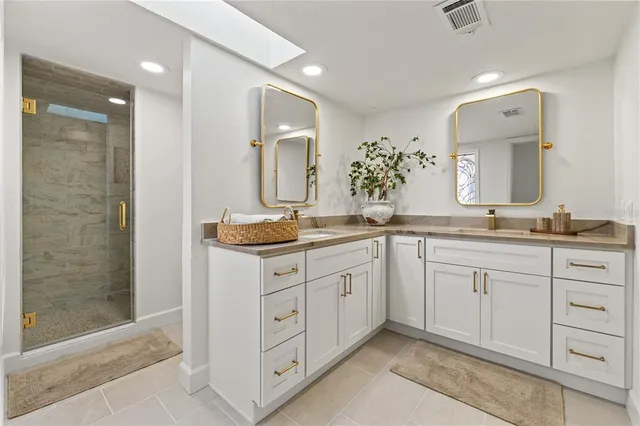 a view of a hallway with wooden floor and a bathroom