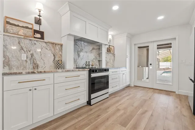 a kitchen with granite countertop white cabinets and stainless steel appliances