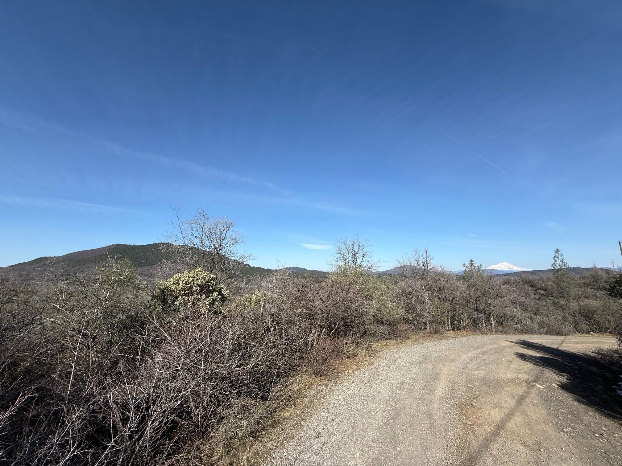 Ranch Road Round Mountain, CA 96084 - Photo 6 of 13 a view of a dry yard with mountains in the background