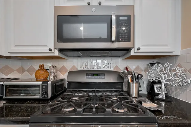 a stove top oven sitting inside of a kitchen