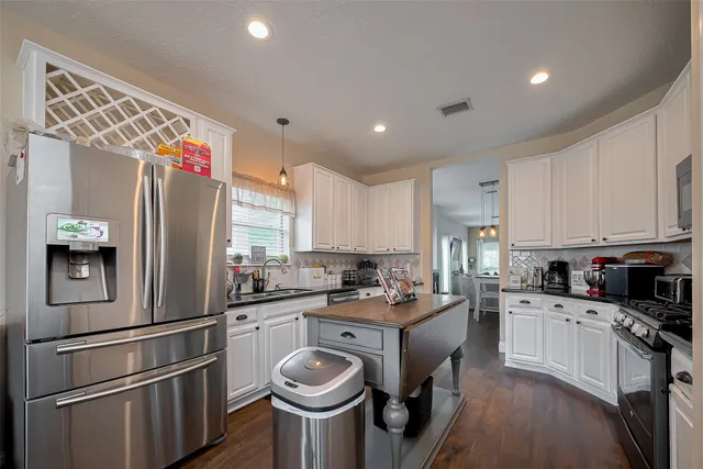 a kitchen with kitchen island a sink stainless steel appliances and cabinets