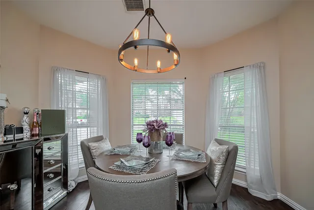 a dining room with furniture a chandelier and wooden floor