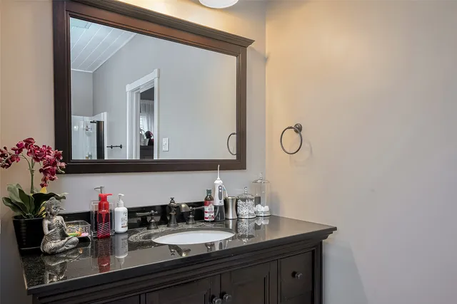 a bathroom with mirror and vanity