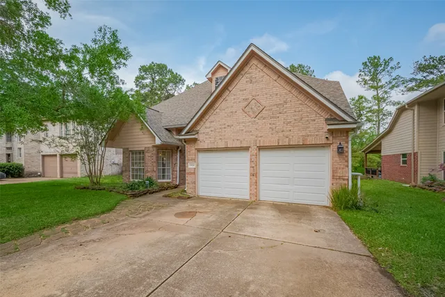 front view of a house with a yard and an trees