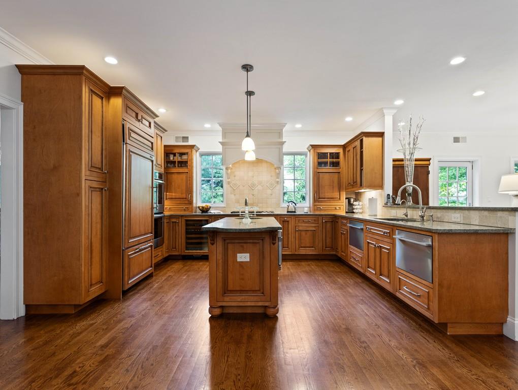 38 Kenilworth Road Wellesley, MA 02482 - Photo 10 of 36 a kitchen with stainless steel appliances granite countertop wooden cabinets a refrigerator a sink a stove a microwave and wooden floor