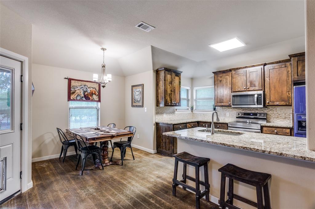 129 Ronnie Lane Weatherford, TX 76088 - Photo 13 of 36 a kitchen with granite countertop sink table and chairs