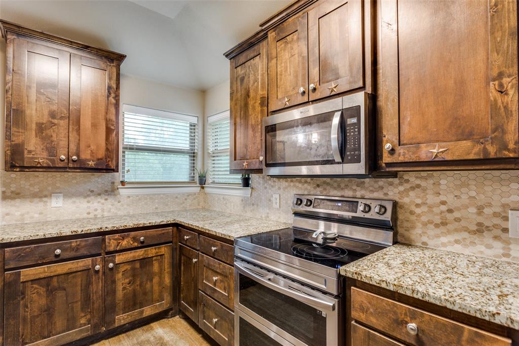 129 Ronnie Lane Weatherford, TX 76088 - Photo 15 of 36 a kitchen with stainless steel appliances granite countertop a sink stove and microwave