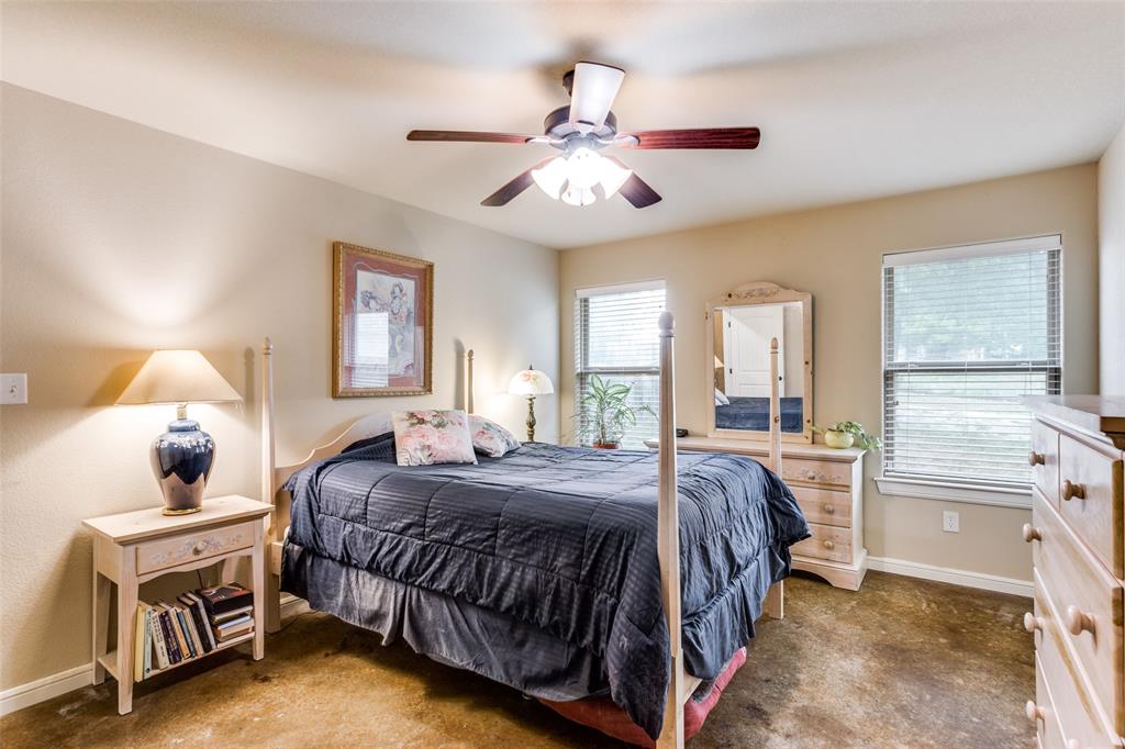 129 Ronnie Lane Weatherford, TX 76088 - Photo 18 of 36 a bedroom with a bed and a chandelier