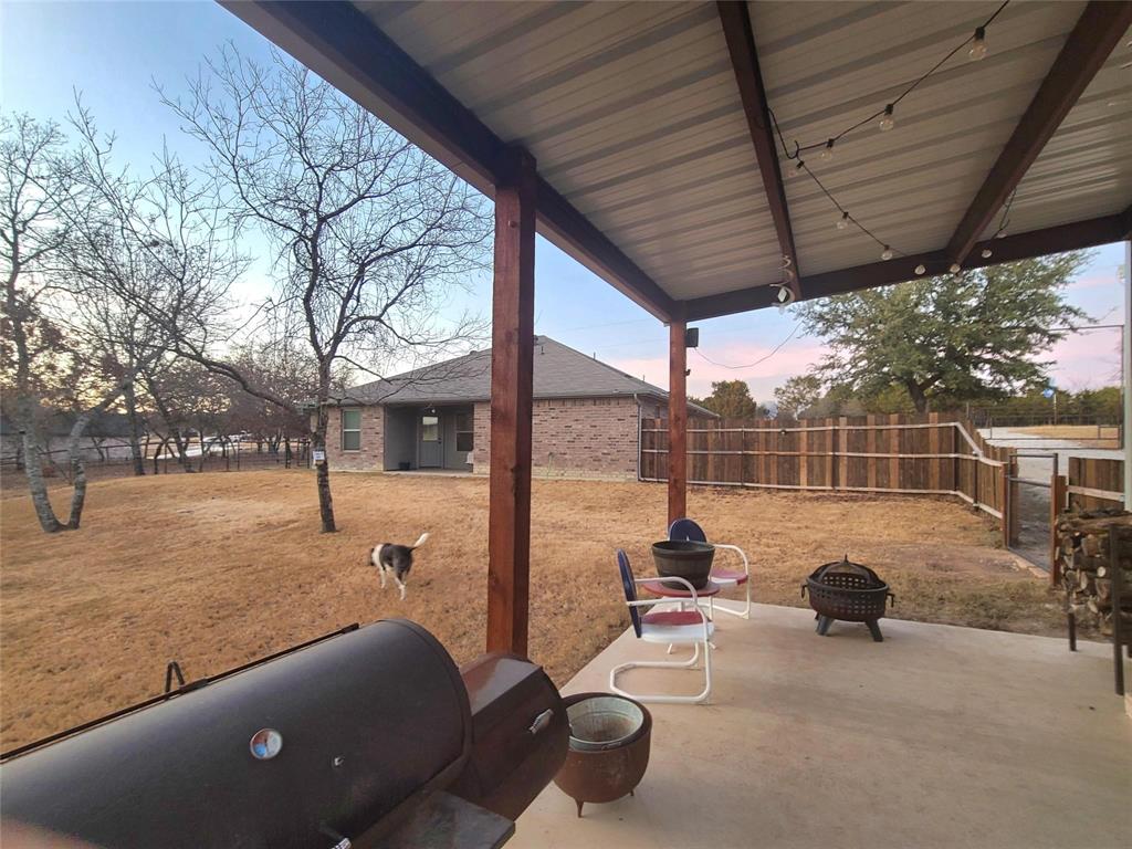 129 Ronnie Lane Weatherford, TX 76088 - Photo 4 of 36 a view of backyard with a table and chairs and iron fence