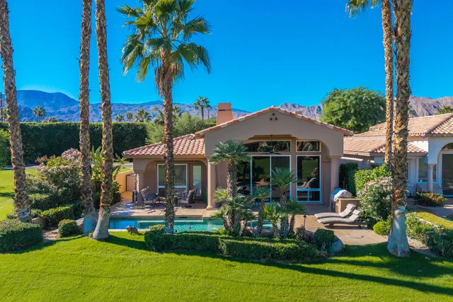 a view of a patio with table and chairs potted plants and palm tree