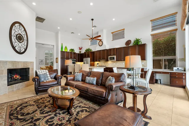 a living room with furniture a fireplace and a large window