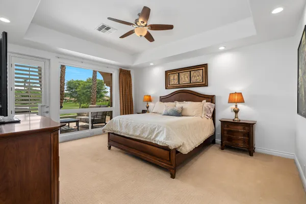 a spacious bedroom with a bed a table and large window