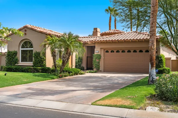 a front view of a house with a garden and garage
