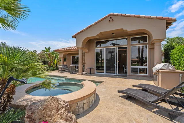 a view of a house with swimming pool and sitting area