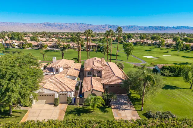 an aerial view of a house with a garden and lake view