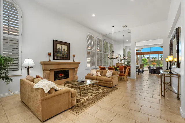 a living room with furniture a fireplace and a chandelier