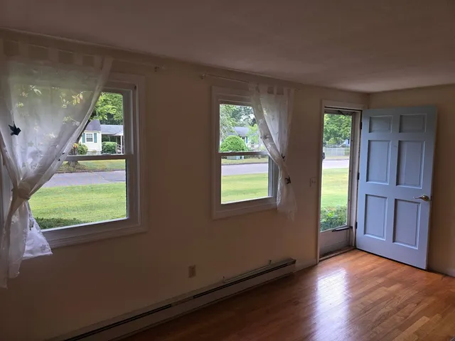 a view of a room with wooden floor and a window