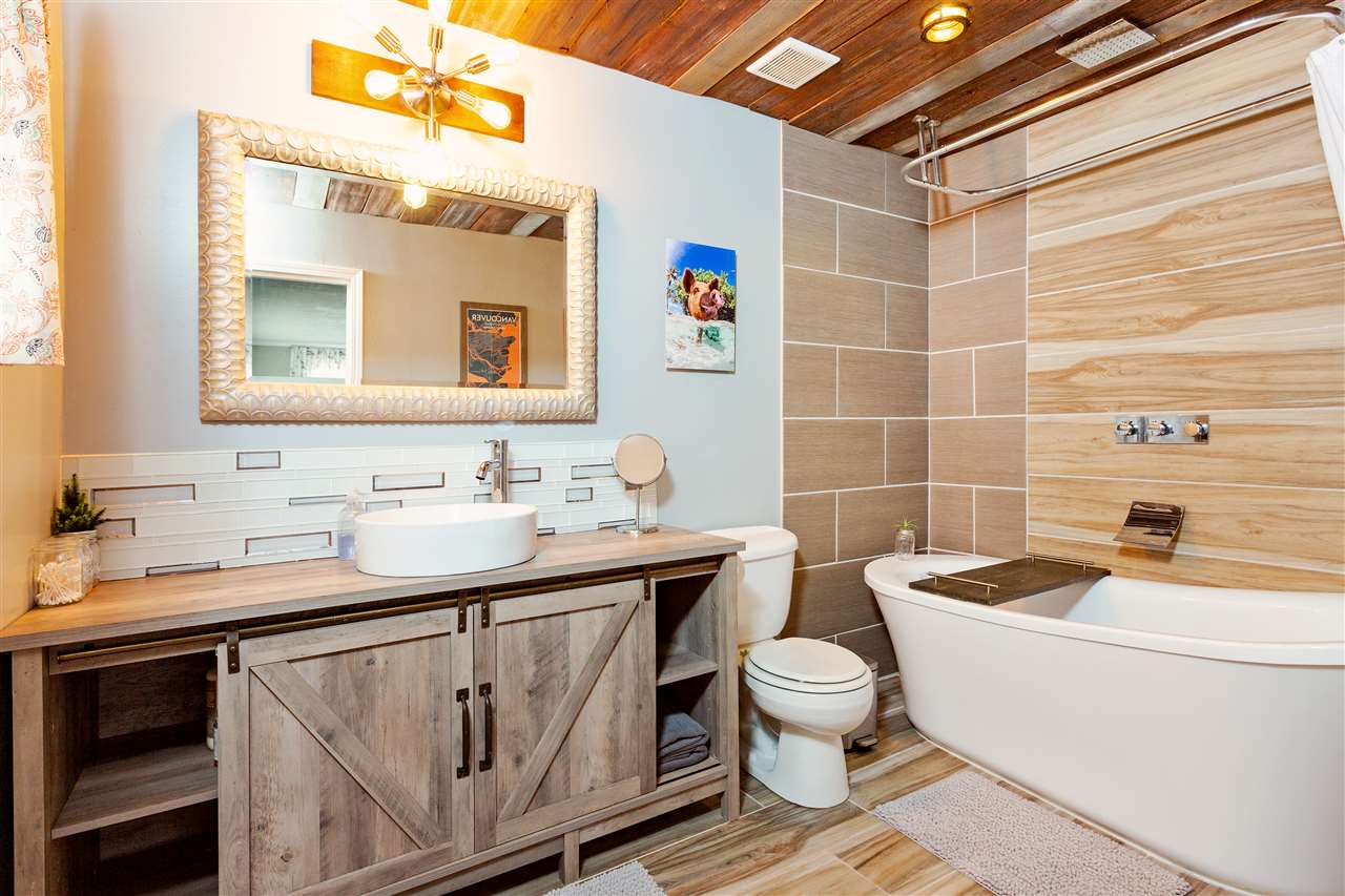 805 Kuulei Street Haiku, HI 96708 - Photo 12 of 28 a bathroom with a granite countertop sink toilet a mirror and bathtub