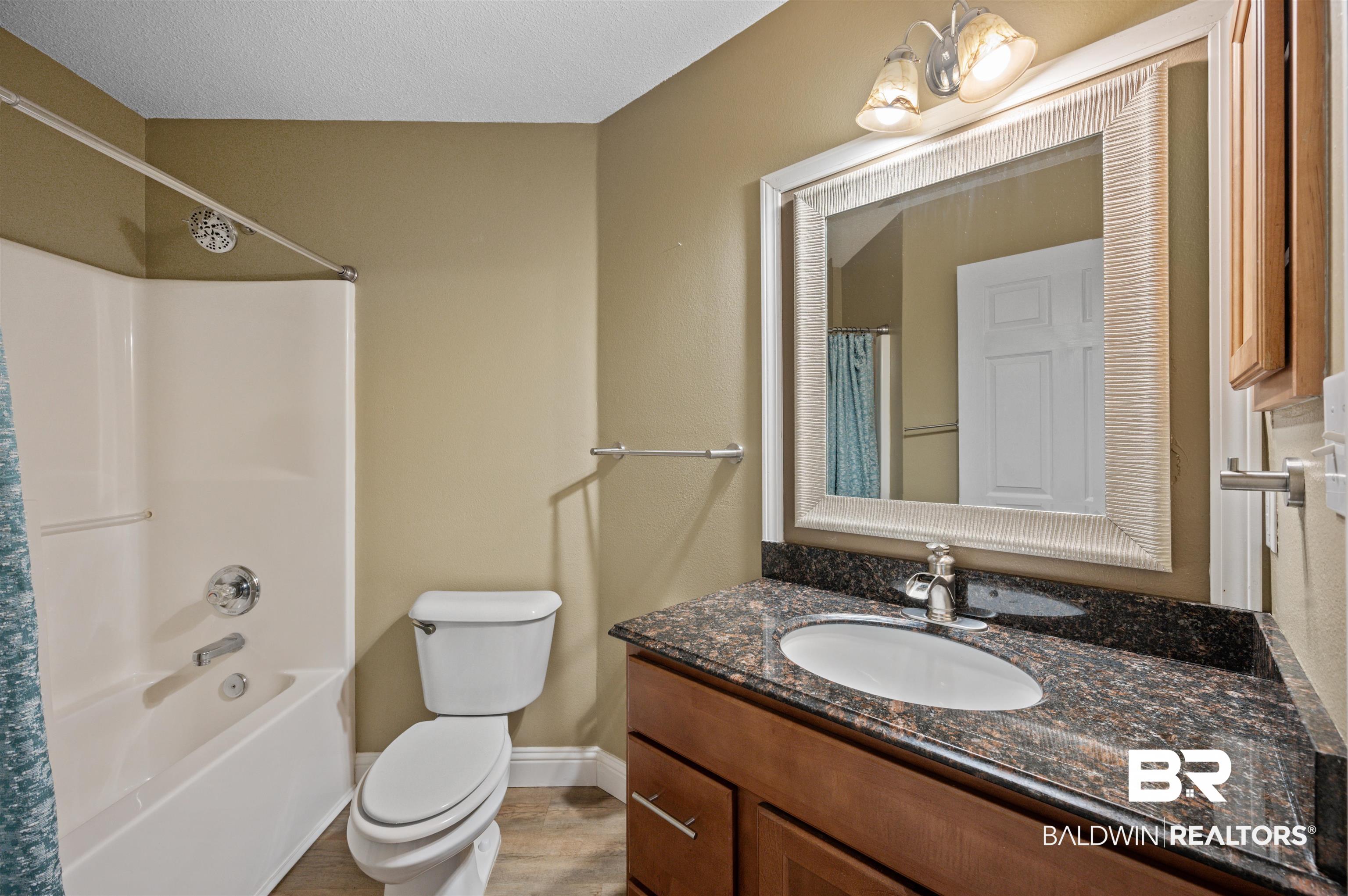 11705 Venice Boulevard Foley, AL 36535 - Photo 19 of 43 Full bathroom featuring shower / bath combo with shower curtain, toilet, and vanity