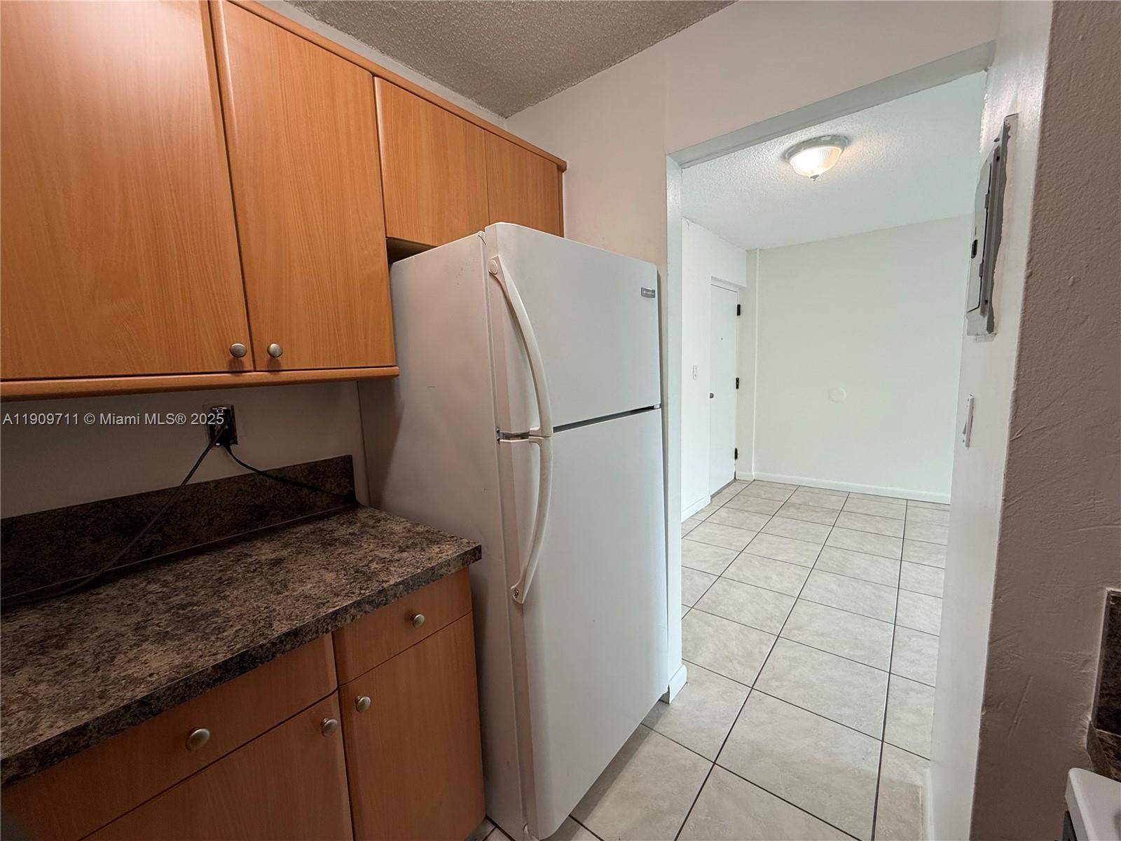 2920 Southwest 28th Terrace, Unit 302 Miami, FL 33133 - Photo 5 of 14 a kitchen with a sink a refrigerator and cabinets