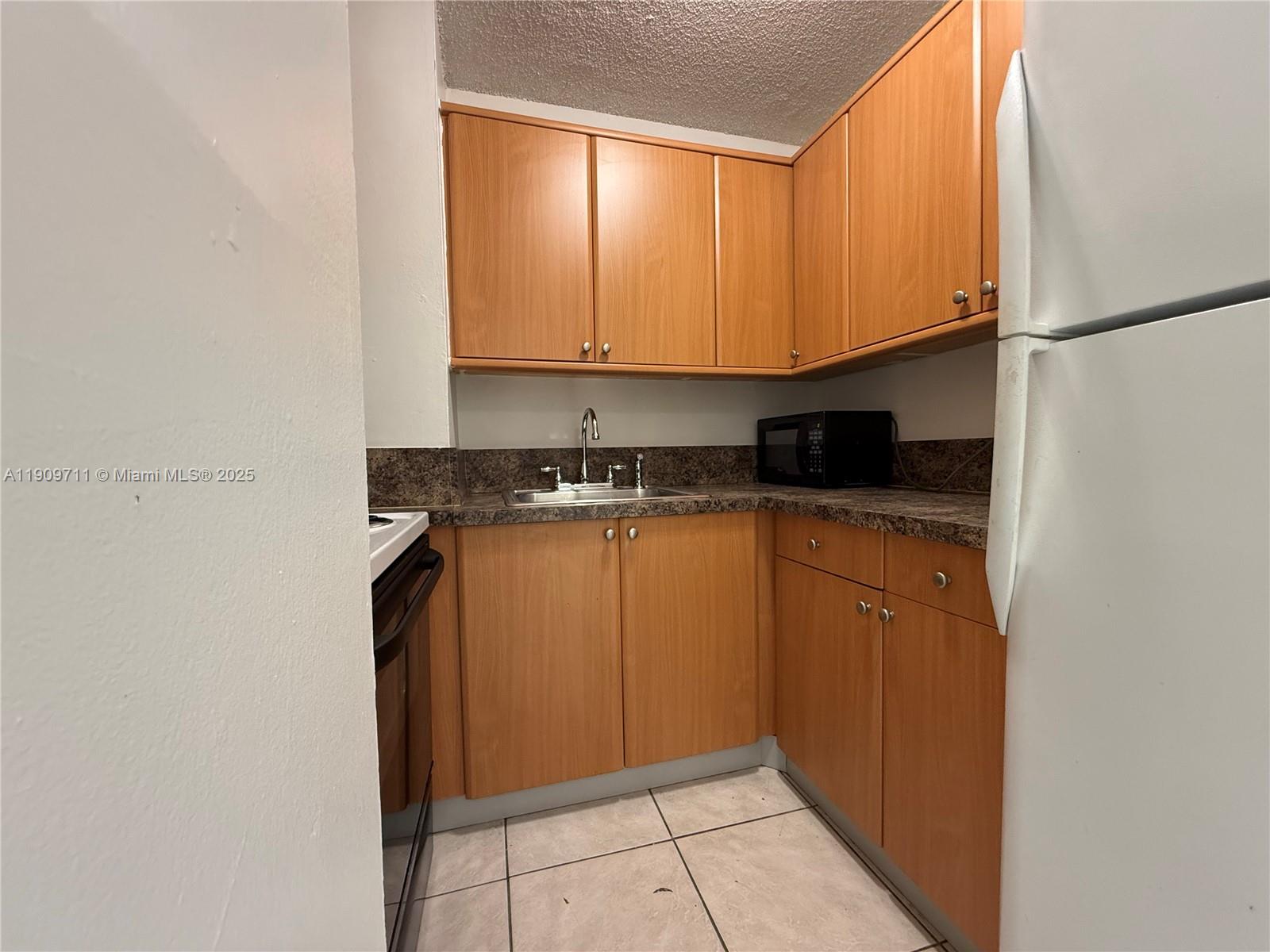 2920 Southwest 28th Terrace, Unit 302 Miami, FL 33133 - Photo 6 of 14 a kitchen with stainless steel appliances granite countertop a refrigerator and a sink