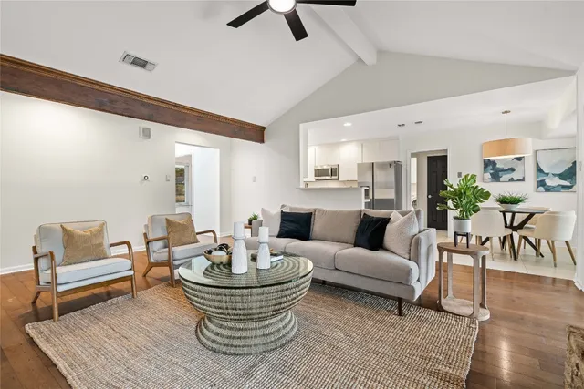 a living room with furniture and a wooden floor