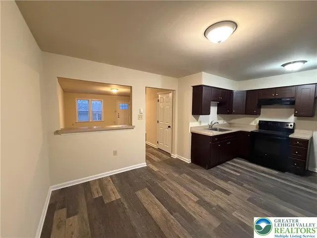 a kitchen with a refrigerator and a stove top oven