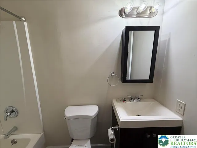 a bathroom with a sink a toilet and mirror