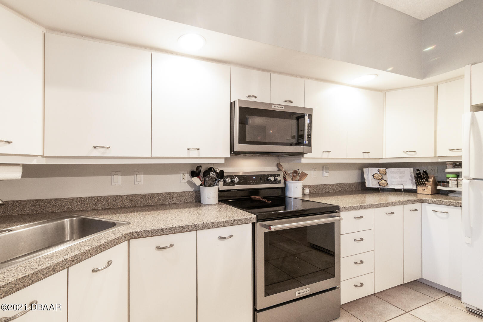 6166 Del Rio Drive Port Orange, FL 32127 - Photo 5 of 53 a kitchen with granite countertop white cabinets and white appliances