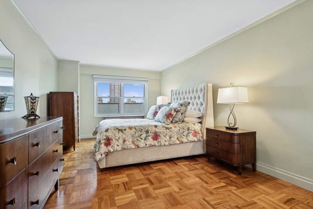 301 East 75th Street, Unit 19B Manhattan, NY 10021 - Photo 14 of 21 a bedroom with a bed and a lamp on dresser