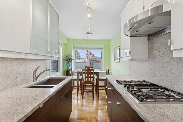a kitchen with a stove a sink a dining table and chairs