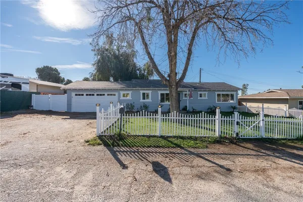 a front view of a house with a garden and trees