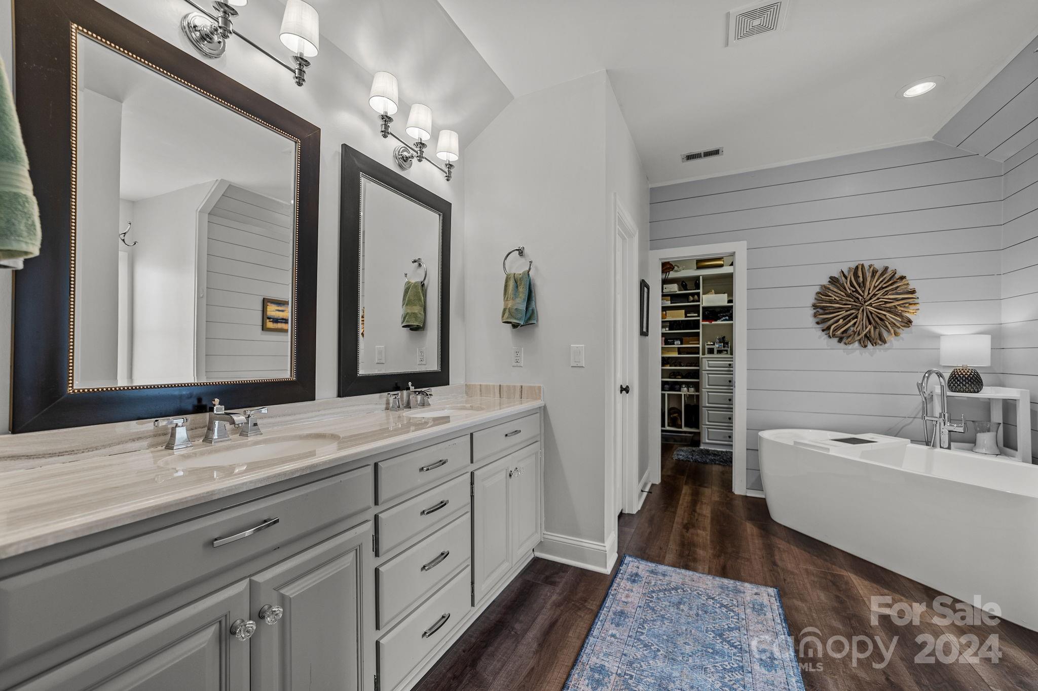 20443 Middletown Road Cornelius, NC 28031 - Photo 22 of 31 a spacious bathroom with a double vanity sink a large mirror and a bathtub