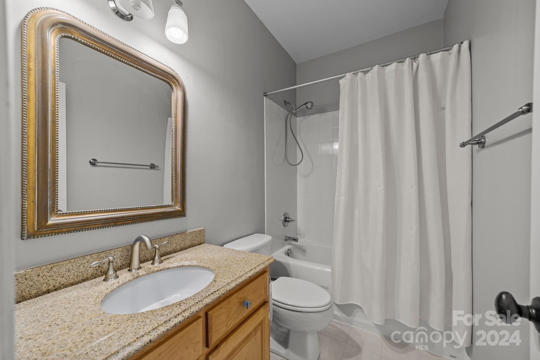 20443 Middletown Road Cornelius, NC 28031 - Photo 30 of 31 a bathroom with a granite countertop sink vanity mirror and toilet