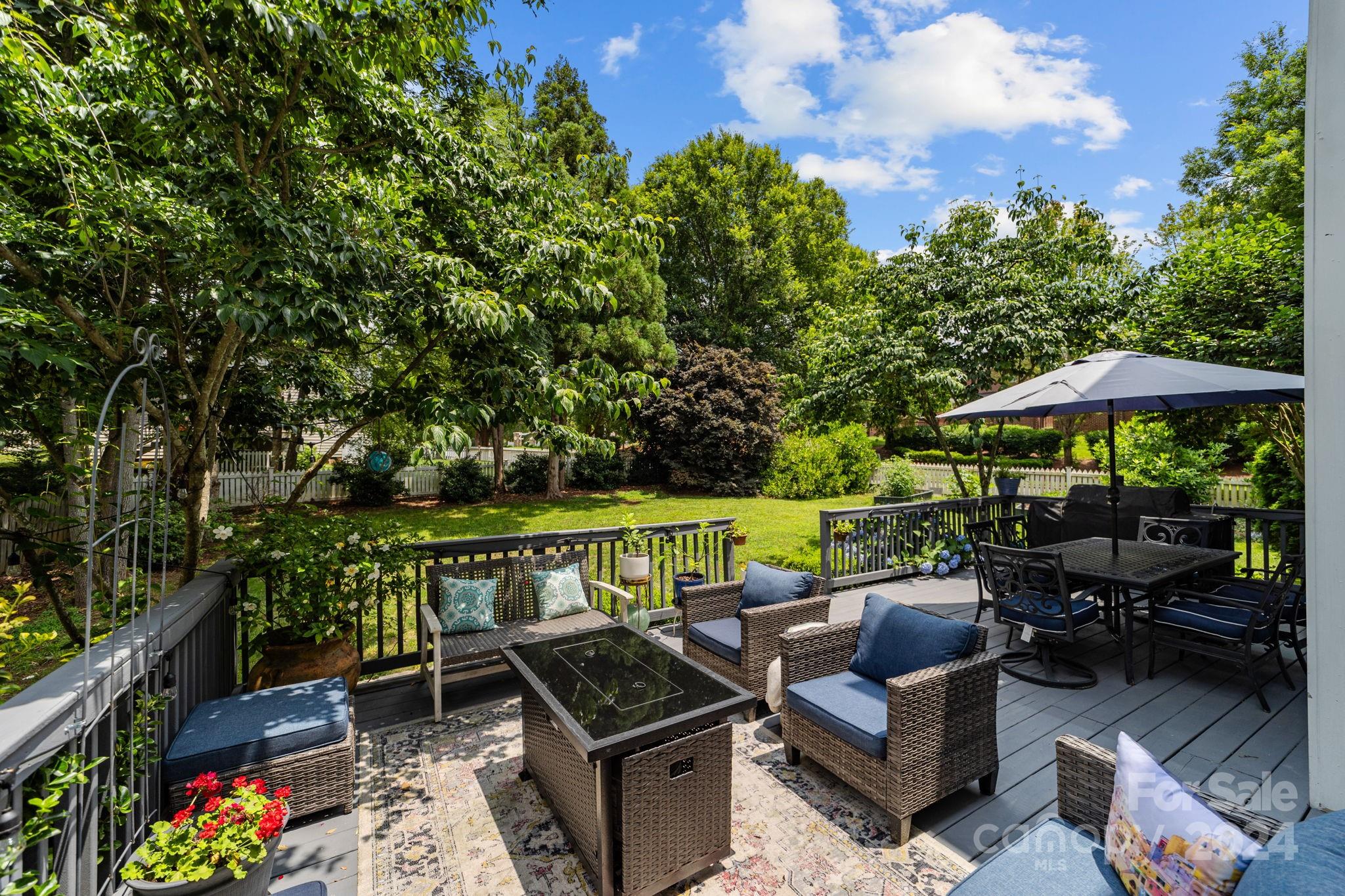 20443 Middletown Road Cornelius, NC 28031 - Photo 4 of 31 an outdoor sitting area with furniture and umbrella