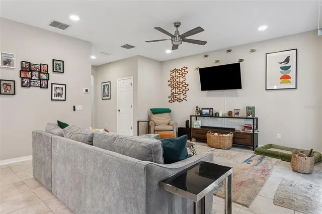 a living room with furniture a flat screen tv and a large window