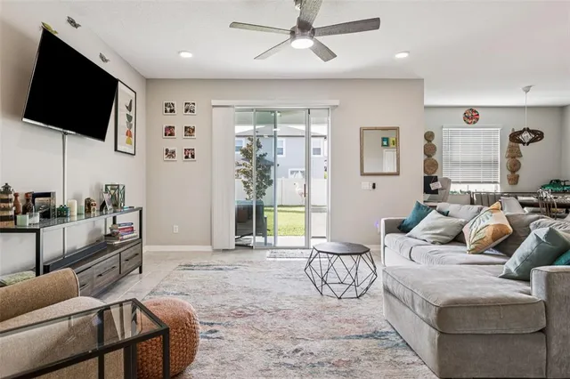 a living room with furniture a flat screen tv and a large window