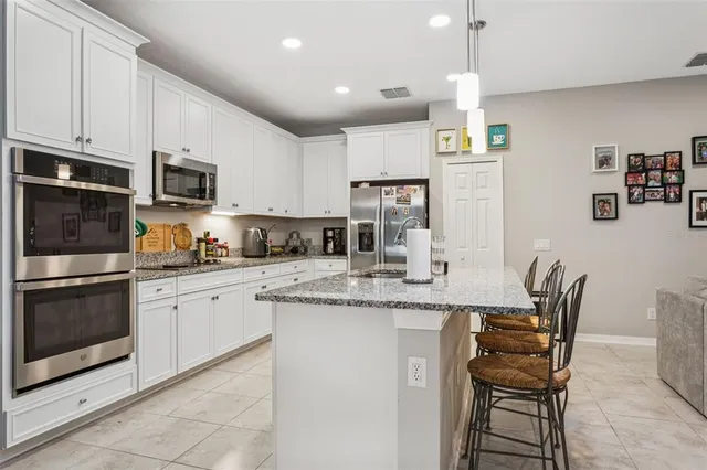a kitchen with kitchen island a sink counter top space appliances and cabinets