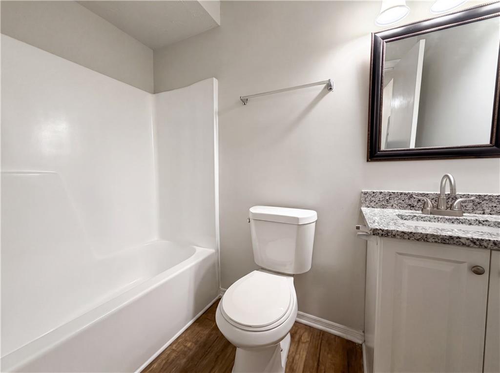 6830 Earlhurst Road Atlanta, GA 30349 - Photo 20 of 27 a bathroom with a granite countertop toilet a sink and a mirror