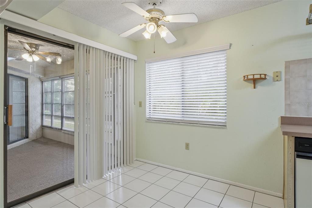 9474 Nakoma Way, Unit E Weeki Wachee, FL 34613 - Photo 11 of 31 a view of an empty room with window and chandelier fan