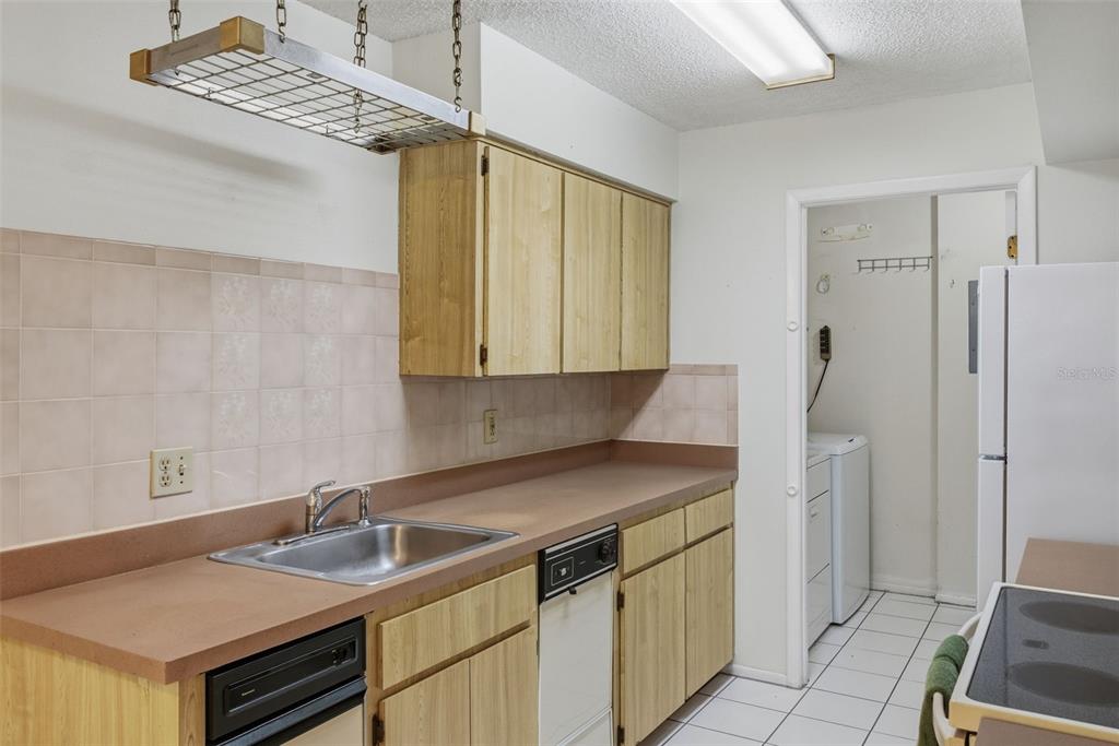 9474 Nakoma Way, Unit E Weeki Wachee, FL 34613 - Photo 13 of 31 a kitchen with stainless steel appliances granite countertop a sink and a refrigerator