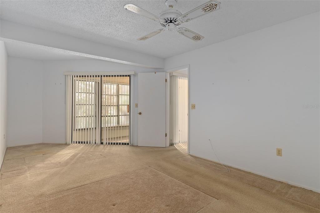 9474 Nakoma Way, Unit E Weeki Wachee, FL 34613 - Photo 18 of 31 an empty room with windows and fan