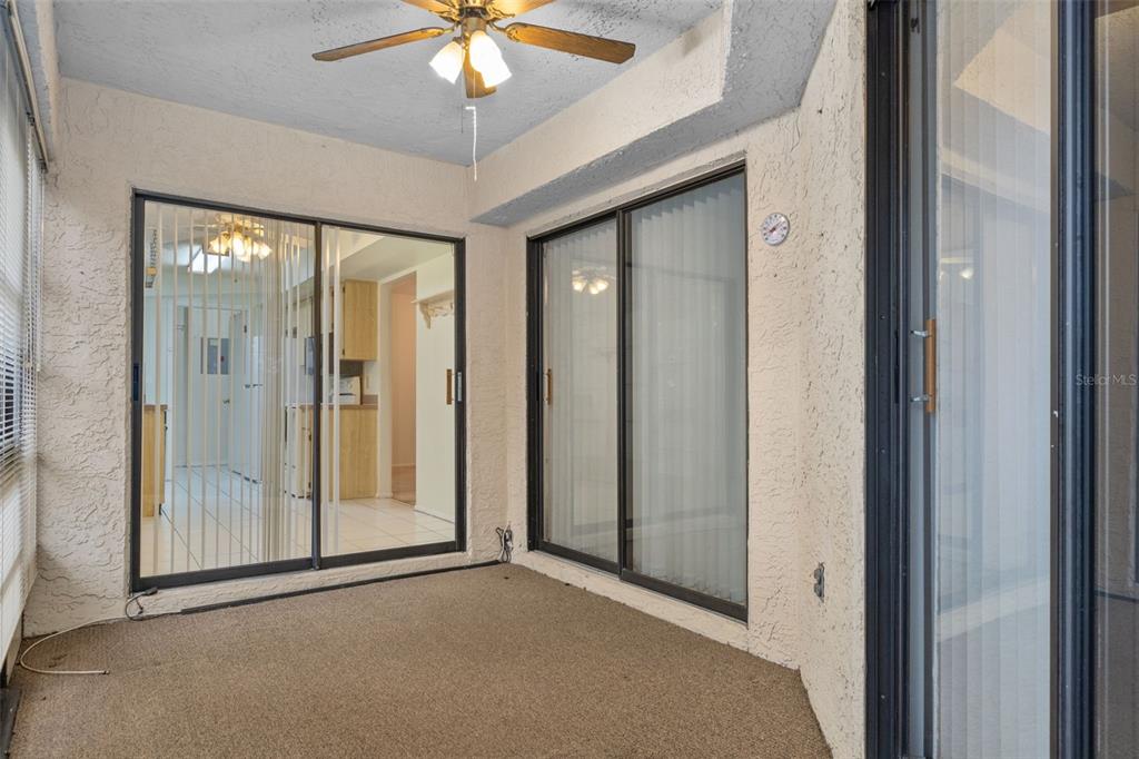 9474 Nakoma Way, Unit E Weeki Wachee, FL 34613 - Photo 26 of 31 a view of a hallway with a chandelier fan and a glass door