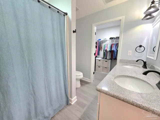 a en suite bathroom with a granite countertop sink and a mirror